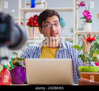 L'uomo fiorista giardiniere vlogger blogger riprese video sulla fotocamera Foto Stock