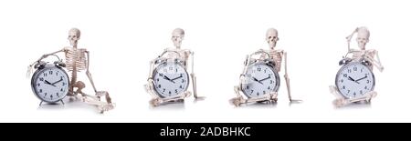 Lo scheletro con la sveglia sul bianco Foto Stock