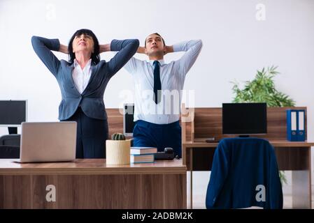 Due dipendenti facendo sport esercizi in ufficio Foto Stock