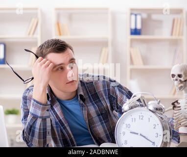 Studente e lo scheletro di preparazione per gli esami di scuola Foto Stock