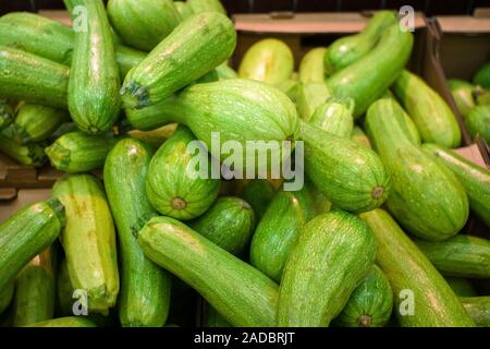 La luce verde di zucchine fresche impilati in un heap ripresa dall'alto ingrandimento. Vendita di verdura matura Foto Stock