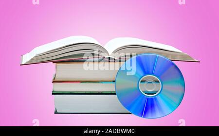 Pila di libri, Libro Aperto e disco DVD come simboli di vecchi e nuovi metodi di memorizzazione delle informazioni Foto Stock