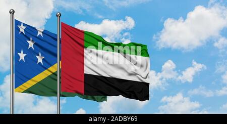 Isole Salomone e Bandiera degli Emirati Arabi Uniti sventolare nel vento contro bianco torbido cielo blu insieme. Concetto di Diplomazia e relazioni internazionali. Foto Stock