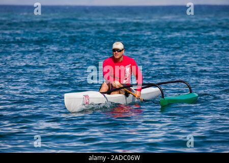 L'uomo paddling da una persona sola canoa outrigger fuori dell'isola di Maui, Hawaii. Immagine modello è rilasciato. Foto Stock