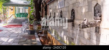 Fila di acqua antinque beccucci in Nepal hotel Foto Stock