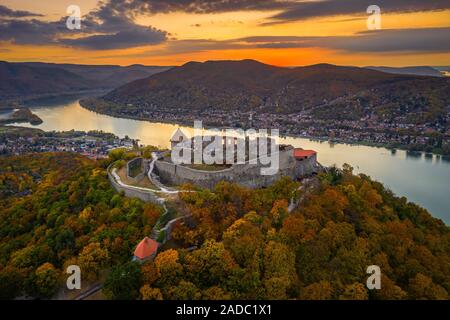 Visegrad, Ungheria - Aerial drone vista sul bellissimo castello di elevata di Visegrad con fogliame di autunno e gli alberi. Dunakanyar e golden sunset a backgrou Foto Stock