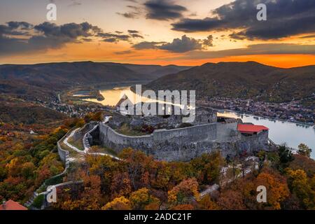 Visegrad, Ungheria - Aerial drone vista sul bellissimo castello di elevata di Visegrad con fogliame di autunno e gli alberi. Dunakanyar e golden sunset a backgrou Foto Stock