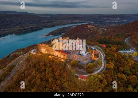 Visegrad, Ungheria - Aerial drone vista sul bellissimo castello di elevata di Visegrad con fogliame di autunno e gli alberi. Dunakanyar a sfondo Foto Stock