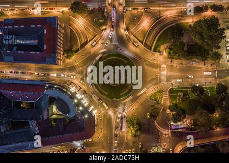 Budapest, Ungheria - Aerial drone vista illuminata piazza Adam Clark, rotonda da sopra a sera con traffico e sentieri di luce Foto Stock