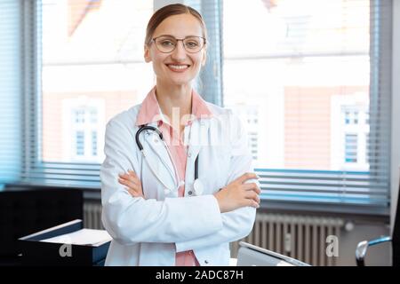 Sorridente medico donna nel suo ufficio Foto Stock