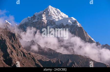 Majestic Thamserku (6652 m) picco torreggiante sopra le nuvole a sunrise in Nepal, montagne himalayane Foto Stock