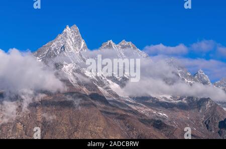 Maestoso torreggiante picco sopra le nuvole a sunrise in Nepal, montagne himalayane Foto Stock