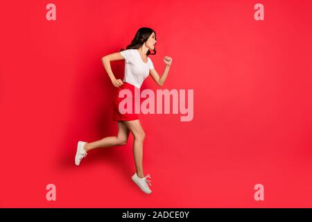 Per tutta la lunghezza del corpo profilo Dimensioni vista laterale di lei bella attraente bella piuttosto grave slim fit-ondulato ragazza dai capelli jumping esecuzione veloce isolate su Foto Stock