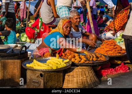 Un uomo e una donna sono che offre spuntini al settimanale mercato vegetale Foto Stock