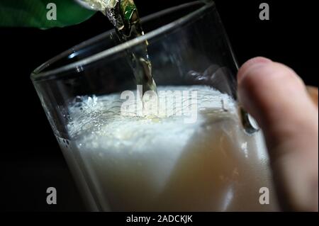 Per spillare la birra in bottiglie di vetro da Can Foto Stock