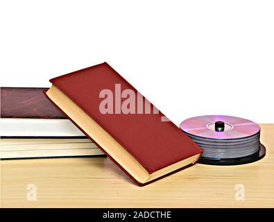 Pila di libri e DVD pacco dischi come simboli di vecchi e nuovi metodi di memorizzazione delle informazioni Foto Stock