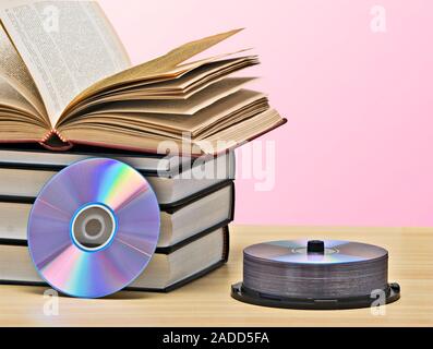 Pila di libri e dischi DVD come simboli di vecchi e nuovi metodi di memorizzazione delle informazioni Foto Stock