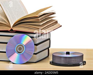 Pila di libri e dischi DVD come simboli di vecchi e nuovi metodi di memorizzazione delle informazioni Foto Stock