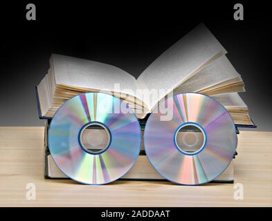 Libri e DVD come simboli di vecchi e nuovi metodi di memorizzazione delle informazioni Foto Stock
