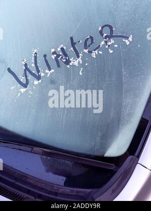 Inverno scritto nel ghiaccio su di un parabrezza di automobile in un freddo gelido mattina Foto Stock