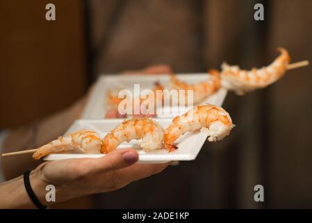 Close up di un gigante alla griglia spiedino di gamberi su un piatto di plastica bianca, Mercato Nishiki, Kyoto, Giappone Foto Stock