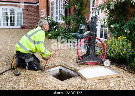 BUCKINGHAM, Regno Unito - 16 ottobre 2019. Un professionista di scarico ingegnere pulizia ispeziona un blocco di scarico domestico Foto Stock