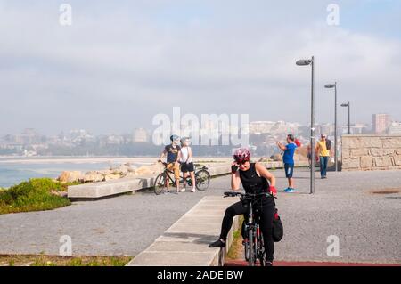 Cicli di donna sulla Eurovelo 1 costa atlantica rotta vicino a Vila Nova de Gaia e Porto, Portogallo. La costa atlantica a sinistra Foto Stock