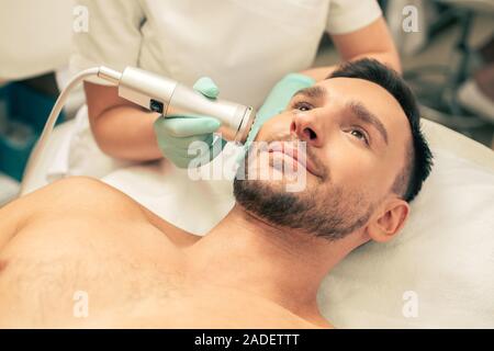 Uomo sorridente presso il moderno metodo di terapia con ossigeno Foto Stock