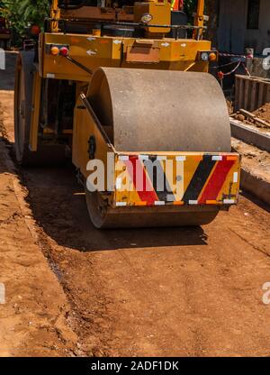 Rulli di strada lavorando su nuove strade sito in costruzione. Macchinari pesanti lavorando su autostrada. Attrezzature da costruzione. La compattazione della strada. Foto Stock