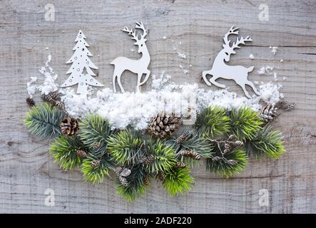 Composizione di natale con cervi e rami di abete rosso su una tavola di legno. Vista dall'alto. Natale o Capodanno saluto il card. Foto Stock