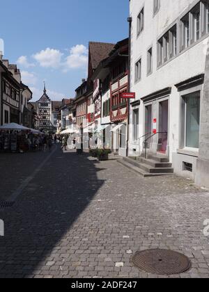 Strada stretta con Untertor gate inferiore europeo in Stein am Rhein città sulla piazza principale del mercato in Svizzera - verticale Foto Stock