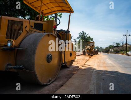 Rulli di strada lavorando su nuove strade sito in costruzione. Macchinari pesanti lavorando su autostrada. Attrezzature da costruzione. La compattazione della strada. Foto Stock