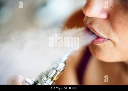 Fumatori e vaping può essere malsana e coinvolgente e rappresentano un rischio per la salute dei polmoni Foto Stock