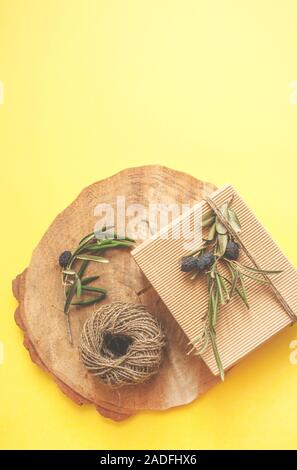 Rifiuti Zero idee regalo. Giftbox si inginocchiò con cavo e olive branch su sfondo di legno e copyspace. Foto Stock