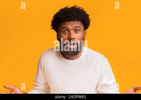 Sorpreso barbuto uomo nero in piedi con la bocca aperta Foto Stock