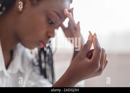 Oro anello di nozze in mano disperata di African American lady Foto Stock