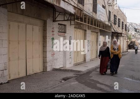 Hebron, West Bank. 4 dicembre, 2019. Palestinesi residenti di Hebron a piedi lungo strade fantasma' una volta vivace con il commercio ma chiusa ai palestinesi dopo il 1994 i disordini. Difesa israeliano Ministro Bennett ha recentemente annunciato la sua approvazione della costituzione di un nuovo quartiere ebraico nella prevalentemente città palestinese di Hebron nei pressi del vecchio mercato di frutta e verdura. I terreni acquistati dagli ebrei che vi risiedono nei primi anni del XIX secolo, fu abbandonato dopo il 1929 massacro in cui 67 ebrei furono assassinati dai rivoltosi arabi. Credito: Nir Alon/Alamy Live News. Foto Stock