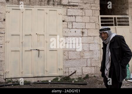 Hebron, West Bank. 4 dicembre, 2019. Palestinesi residenti di Hebron a piedi lungo strade fantasma' una volta vivace con il commercio ma chiusa ai palestinesi dopo il 1994 i disordini. Difesa israeliano Ministro Bennett ha recentemente annunciato la sua approvazione della costituzione di un nuovo quartiere ebraico nella prevalentemente città palestinese di Hebron nei pressi del vecchio mercato di frutta e verdura. I terreni acquistati dagli ebrei che vi risiedono nei primi anni del XIX secolo, fu abbandonato dopo il 1929 massacro in cui 67 ebrei furono assassinati dai rivoltosi arabi. Credito: Nir Alon/Alamy Live News. Foto Stock