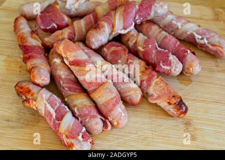 Cucinato in suini coperte, un inglese tradizionale cibo di Natale di salsicce avvolto in pancetta Foto Stock