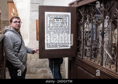 Hebron, West Bank. 4 dicembre, 2019. Un uomo apre l'arca per visualizzare la Torah e scorre nella Avraham Avinu Sinagoga a Hebron. Difesa israeliano Ministro Bennett ha recentemente annunciato la sua approvazione della costituzione di un nuovo quartiere ebraico nella prevalentemente città palestinese di Hebron nei pressi del vecchio mercato di frutta e verdura. I terreni acquistati dagli ebrei che vi risiedono nei primi anni del XIX secolo, fu abbandonato dopo il 1929 massacro in cui 67 ebrei furono assassinati dai rivoltosi arabi. Credito: Nir Alon/Alamy Live News. Foto Stock