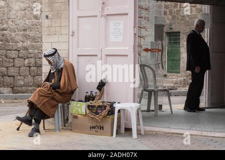 Hebron, West Bank. 4 dicembre, 2019. Anziani uomini palestinesi bighellonare un 'ghost Street', una volta vivace con il commercio ma chiusa ai palestinesi dopo il 1994 i disordini. Difesa israeliano Ministro Bennett ha recentemente annunciato la sua approvazione della costituzione di un nuovo quartiere ebraico nella prevalentemente città palestinese di Hebron nei pressi del vecchio mercato di frutta e verdura. I terreni acquistati dagli ebrei che vi risiedono nei primi anni del XIX secolo, fu abbandonato dopo il 1929 massacro in cui 67 ebrei furono assassinati dai rivoltosi arabi. Credito: Nir Alon/Alamy Live News. Foto Stock