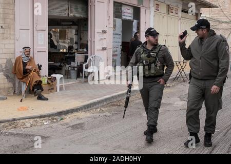 Hebron, West Bank. 4 dicembre, 2019. Poliziotti di frontiera patrol un 'ghost Street', una volta vivace con il commercio ma chiusa ai palestinesi dopo il 1994 i disordini. Difesa israeliano Ministro Bennett ha recentemente annunciato la sua approvazione della costituzione di un nuovo quartiere ebraico nella prevalentemente città palestinese di Hebron nei pressi del vecchio mercato di frutta e verdura. I terreni acquistati dagli ebrei che vi risiedono nei primi anni del XIX secolo, fu abbandonato dopo il 1929 massacro in cui 67 ebrei furono assassinati dai rivoltosi arabi. Credito: Nir Alon/Alamy Live News. Foto Stock