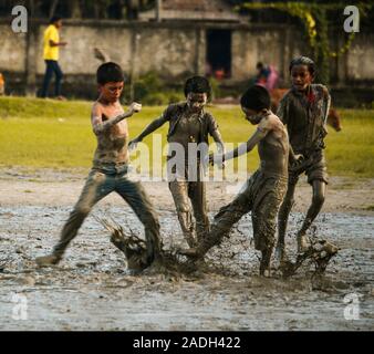 Alcuni bambini stanno giocando nei campi fangosi Foto Stock