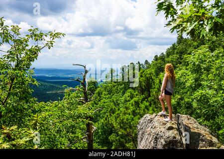Una ragazza sorge su una rupe di roccia che si affaccia sulla Ozark Mountains nello stato di Arkansas, Stati Uniti. Foto Stock