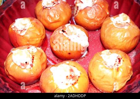 Deliziose mele cotte con uvetta, ricotta e noci, spolverati con zucchero a velo, in una teglia da forno di festa e dessert fatti in casa Foto Stock