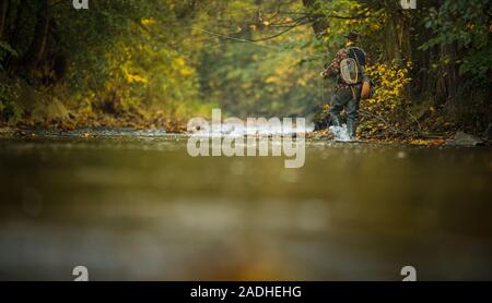 Pescatore a mosca la pesca con la mosca su di uno splendido fiume di montagna Foto Stock