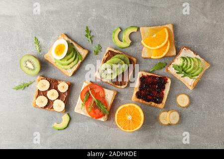 Deliziosi panini assortiti su sfondo grigio, vista dall'alto Foto Stock