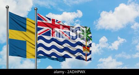 In Svezia e in Territorio britannico dell'Oceano Indiano bandiera sventolare nel vento contro bianco torbido cielo blu insieme. Concetto di Diplomazia e relazioni internazionali. Foto Stock