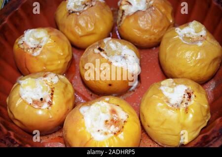 Deliziose mele cotte con uvetta, ricotta e noci, spolverati con zucchero a velo, in una teglia da forno di festa e dessert fatti in casa Foto Stock