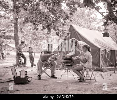 Anni Cinquanta anni sessanta la famiglia di 5 tenda CAMPEGGIO MOM cooking per colazione che serve la figlia e il papà due ragazzi poggiando su albero con canna da pesca - c489 DEB001 HARS COLAZIONE ABBIGLIAMENTO MOM nostalgico che serve le madri vecchio tempo NOSTALGIA APPOGGIATA OLD FASHION capretti boschi stile griglieria sicurezza pace TEAMWORK LANTERNA FIGLI VACANZA FAMIGLIE LIFESTYLE cinque femmine sposato 5 coniuge rurale mariti salubrità natura spazio copia amicizia a tutta lunghezza a mezza lunghezza LADIES figlie persone maschi ragazzo adolescente campeggio padri ASTA B&W PARTNER ESTATE libertà felicità avventura di svago e ricreazione DADS CAFFETTIERA TENDE SGABELLI Foto Stock